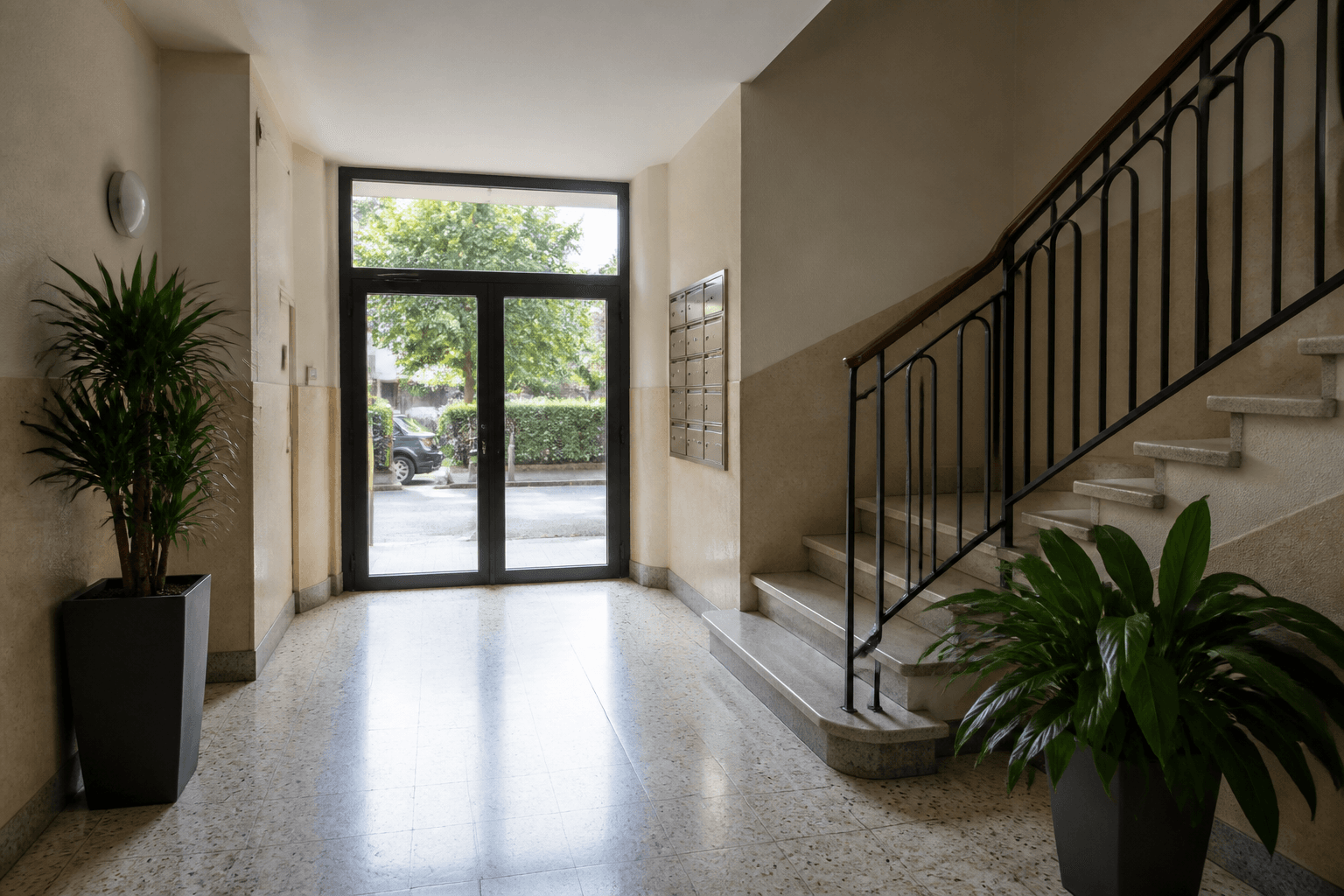 Hall d’immeuble à Nice, sol et porte vitrée entretenus, lumière naturelle.
